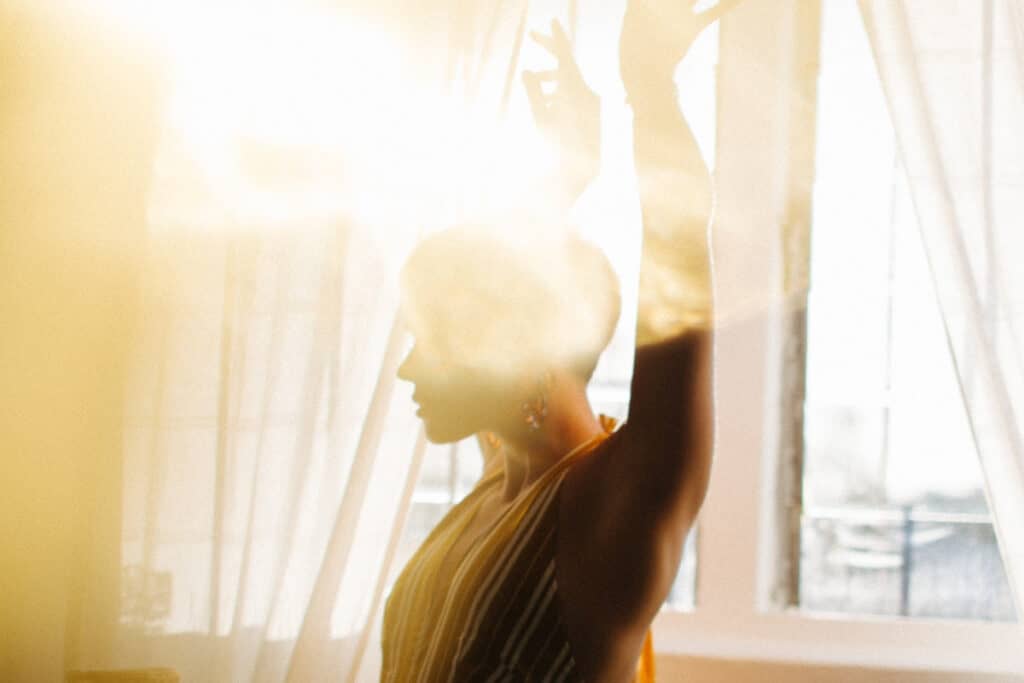 woman dancing in light with lens flare